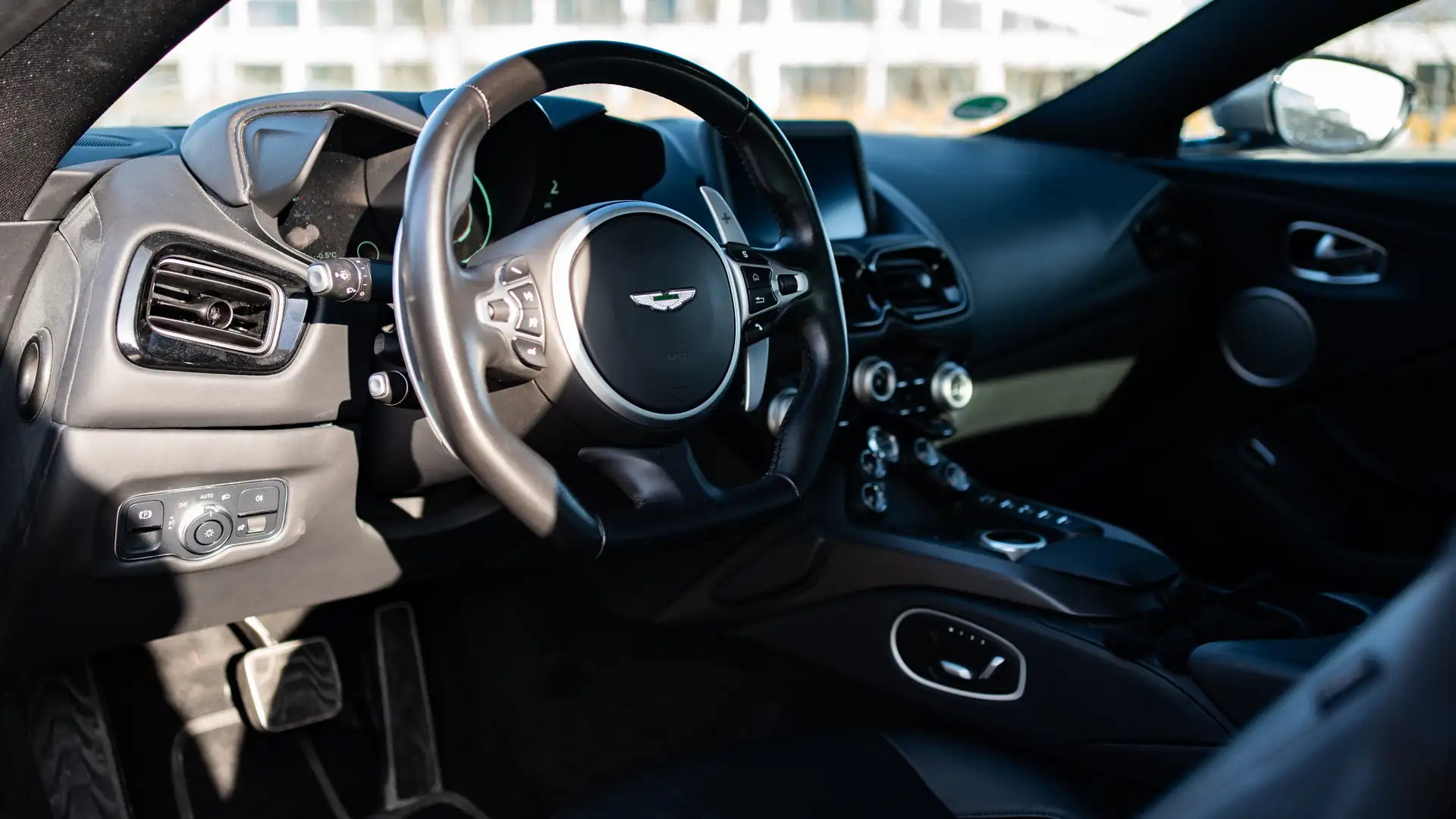 The steering wheel and interior of an Aston Martin Vantage Roadster.